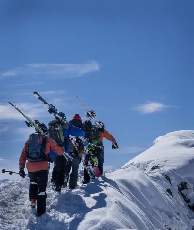 Ski tourers carrying their skis up a ridge in Val d'Aran