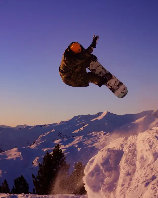 Snowboarder in the air at sunset